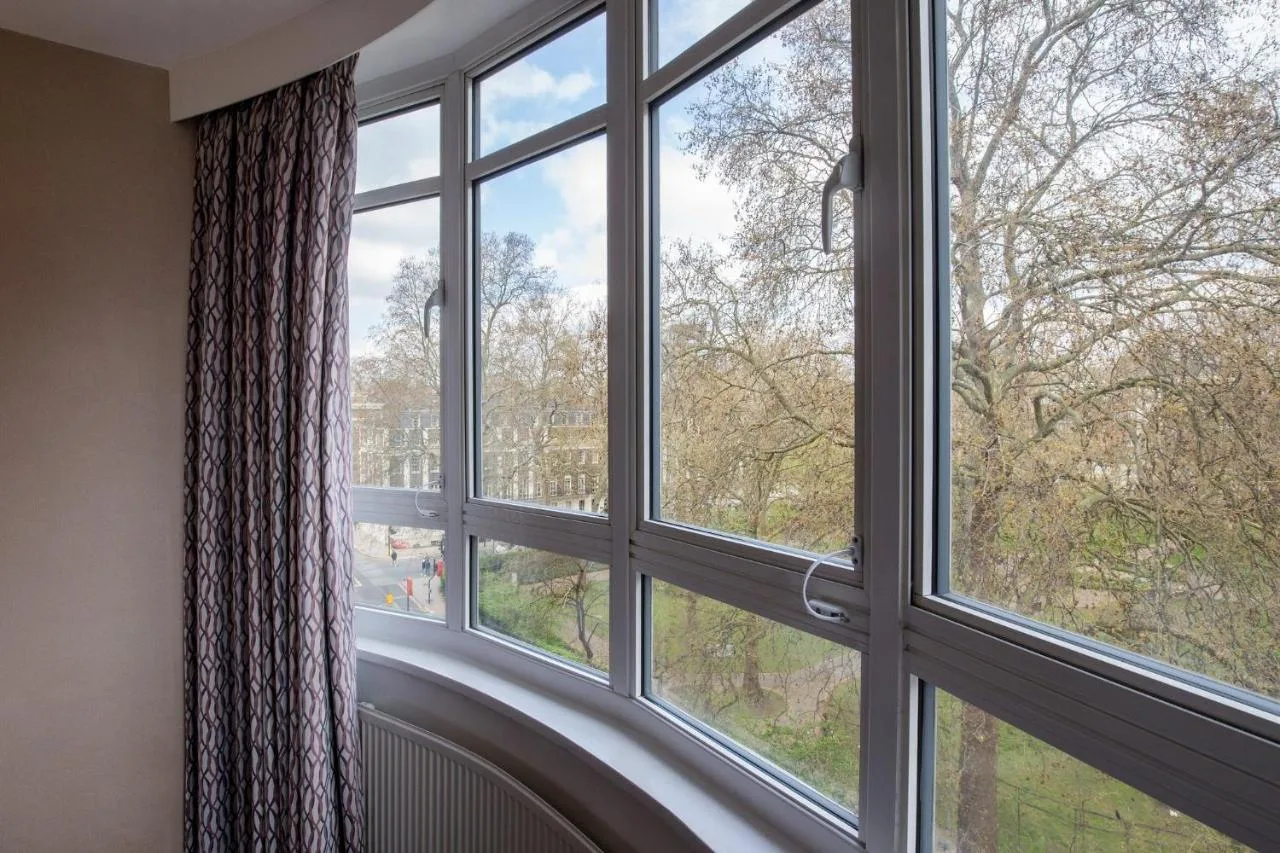 a room with a window looking out at the trees at Tavistock Hotel in London