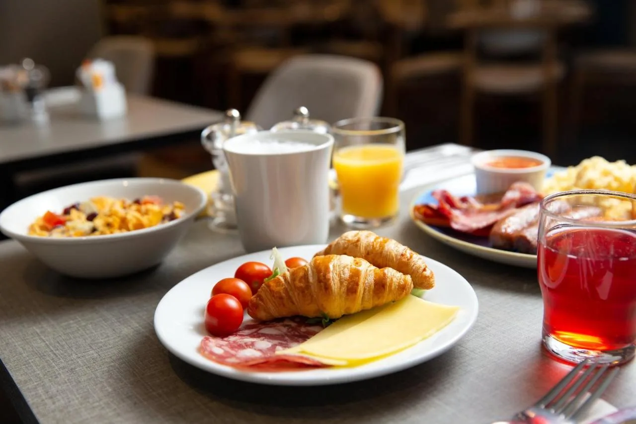 a table topped with plates of breakfast foods and drinks at Tavistock Hotel in London